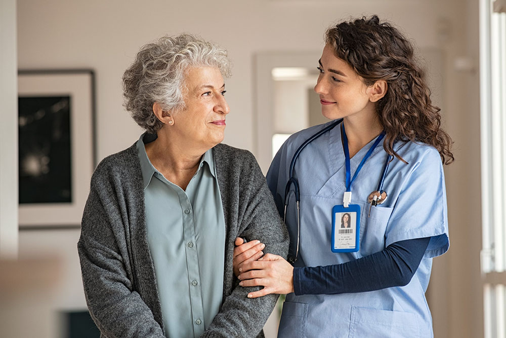 Caregiver assist senior woman at home